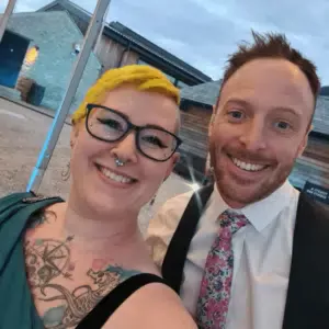 Bekah and Dave are smiling at the camera dressed up for an awards evening.